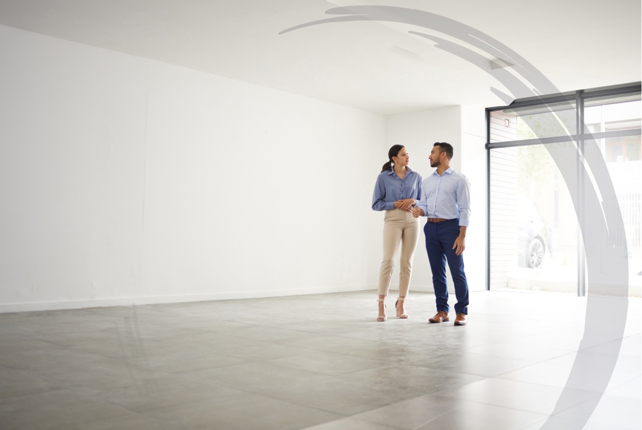 a young couple stand in their new, large apartment