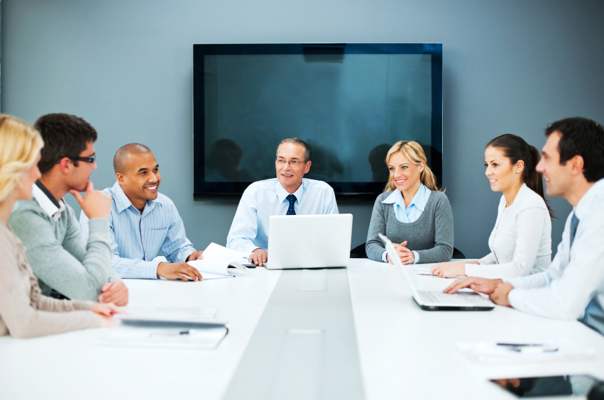 7 business people sit at a conference table in an office building