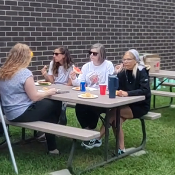 women sitting at a picnic table